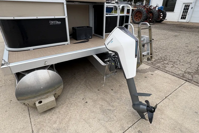 Slide: The Image of 2015 Bennington 18 SLX pontoon boat with Mercury outboard motor on concrete surface. - 5