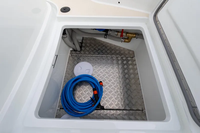 Slide: The Image of Storage compartment of 2026 Targa 27.2 boat with blue hose and metal flooring. - 10