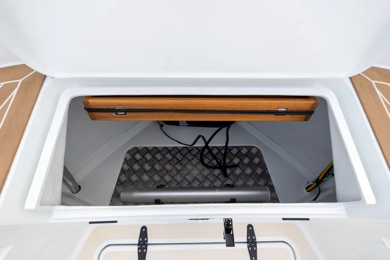 Slide: The Image of Storage compartment of 2026 Targa 27.2 boat with wooden accents and metal flooring. - 13