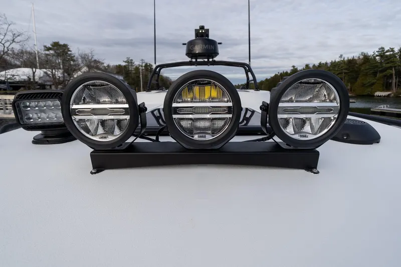 Slide: The Image of Powerful LED lights on 2026 Targa 27.2 boat, docked near a wooded shoreline. - 18