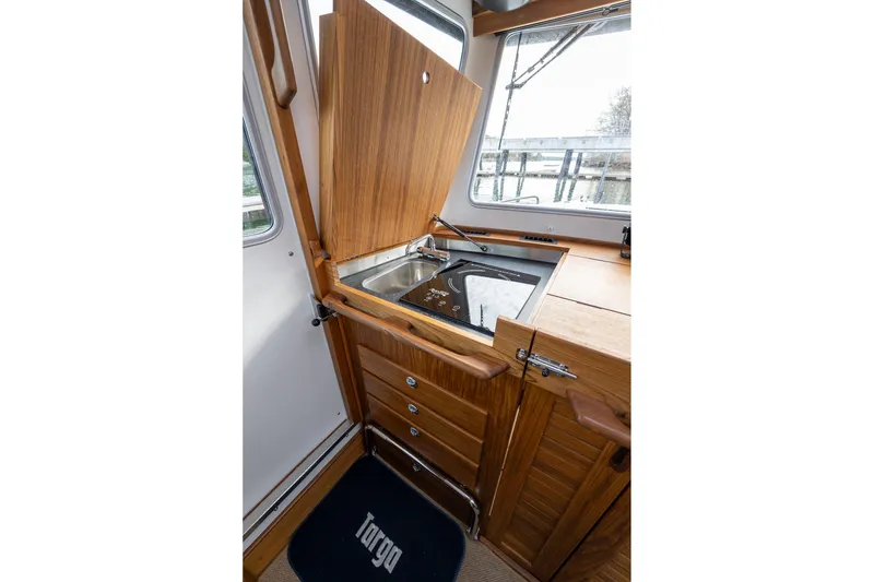 Slide: The Image of 2026 Targa 27.2 boat interior with wooden cabinetry and compact kitchen sink. - 40