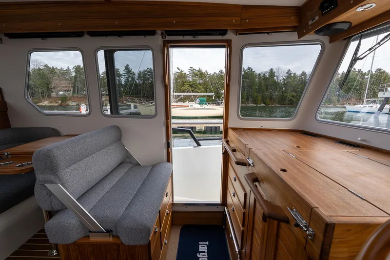 Slide: The Image of Interior of 2026 Targa 27.2 boat with wooden cabinetry and gray seating, dockside view. - 53