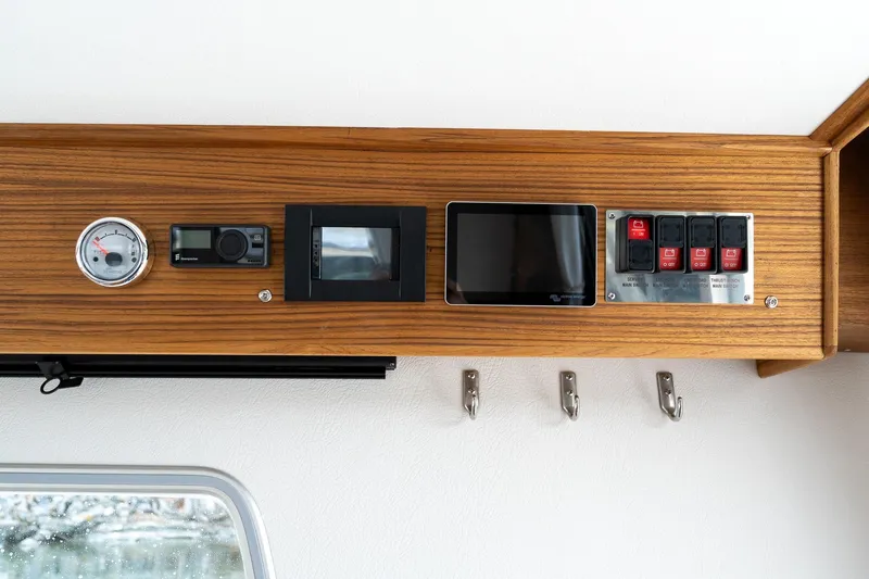 Slide: The Image of Control panel of 2026 Targa 27.2 boat with gauges and switches on wooden dashboard. - 56