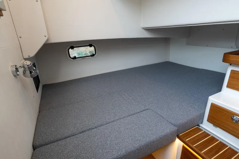 Slide: The Image of Cozy interior cabin of 2026 Targa 27.2 boat with gray bedding and wooden accents. - 61