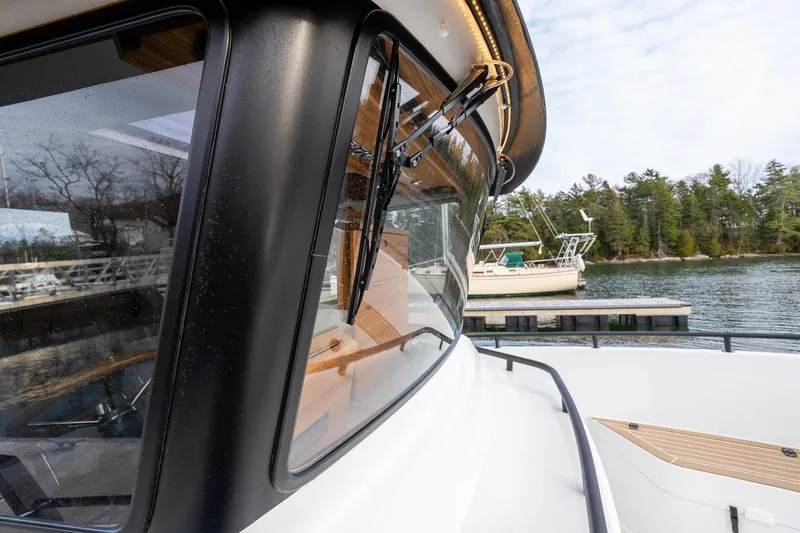 Slide: The Image of 2026 Targa 27.2 boat docked by a scenic lakeside with trees. - 7