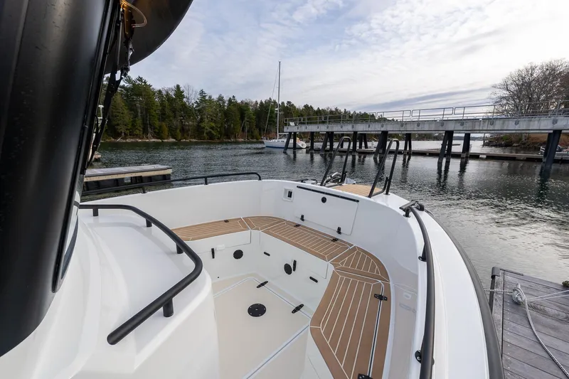 Slide: The Image of 2026 Targa 27.2 boat docked by a scenic waterfront with trees and pier. - 8