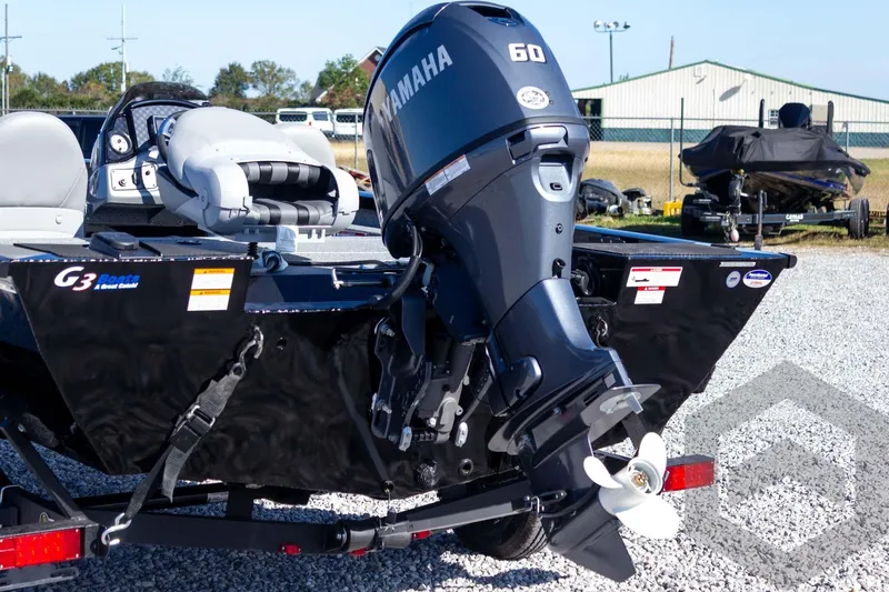 Slide: The Image of 2026 G3 Sportsman 1610 boat with Yamaha 60 outboard motor, parked on gravel. - 16
