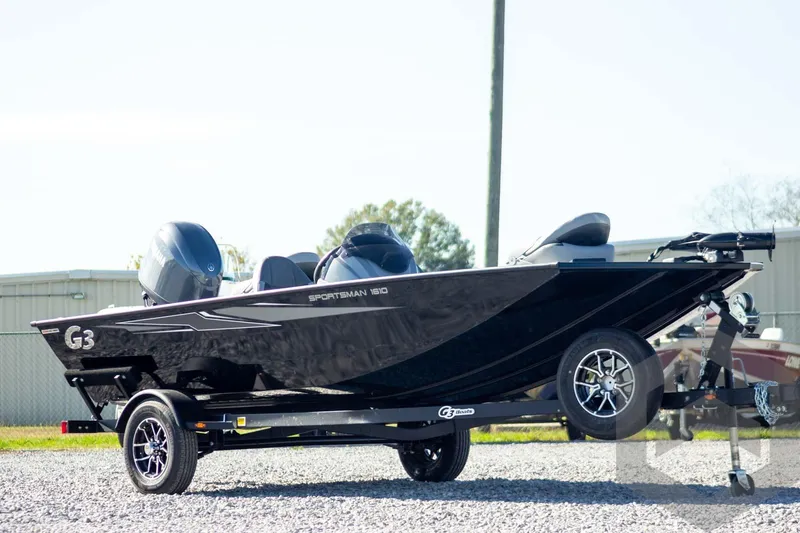 Slide: The Image of 2026 G3 Sportsman 1610 boat on trailer, sleek black design, parked outdoors. - 3