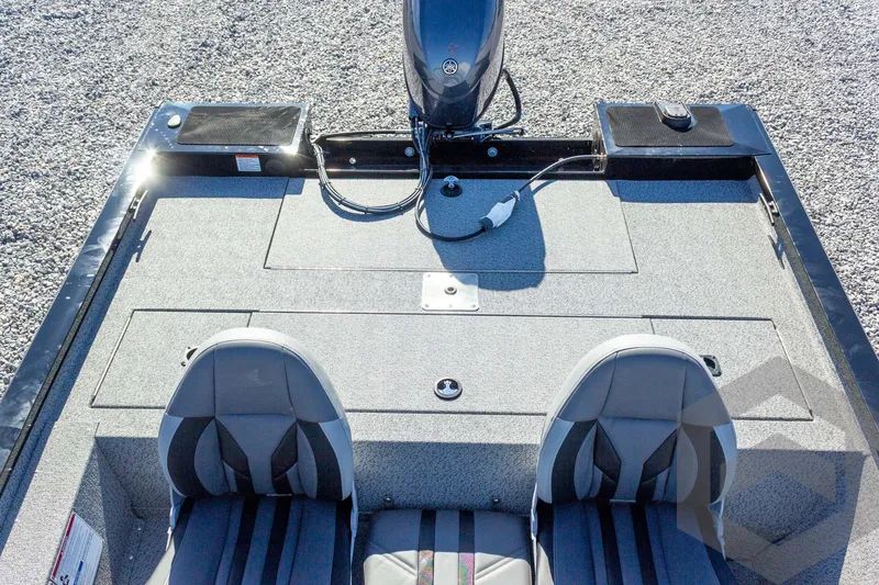 Slide: The Image of 2026 G3 Sportsman 1610 boat interior with dual seats and motor, on gravel surface. - 40