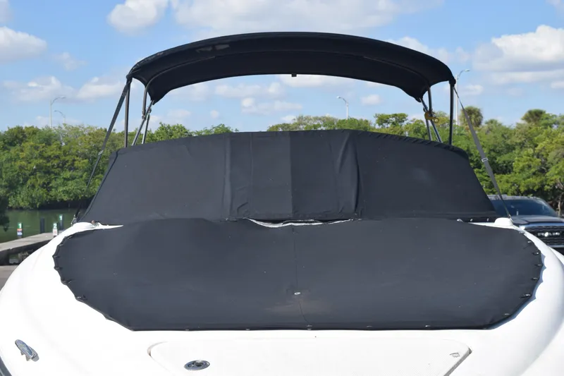 Slide: The Image of 2005 Sea Ray SLX 280 boat with black cover and canopy, docked outdoors. - 14