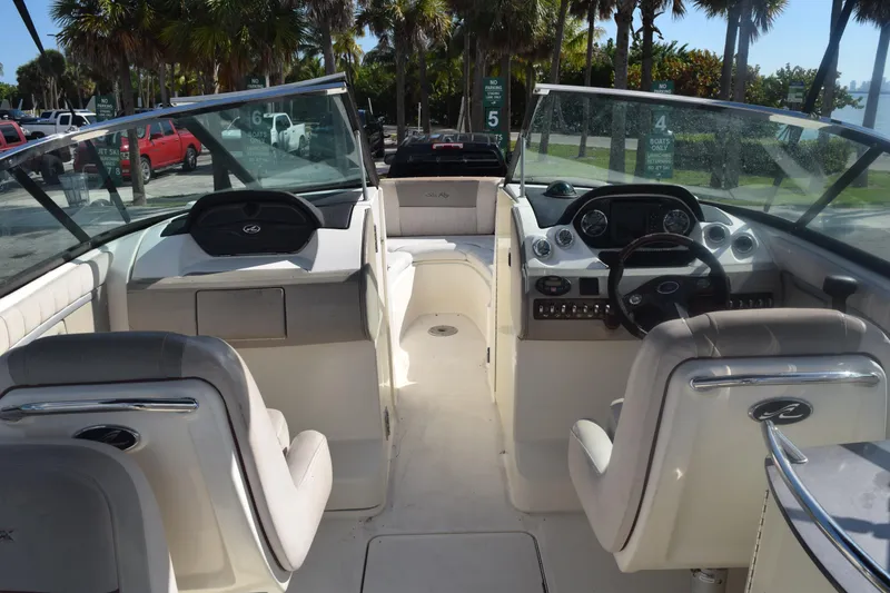 Slide: The Image of 2005 Sea Ray SLX 280 boat interior with seating and helm, parked near waterfront. - 17