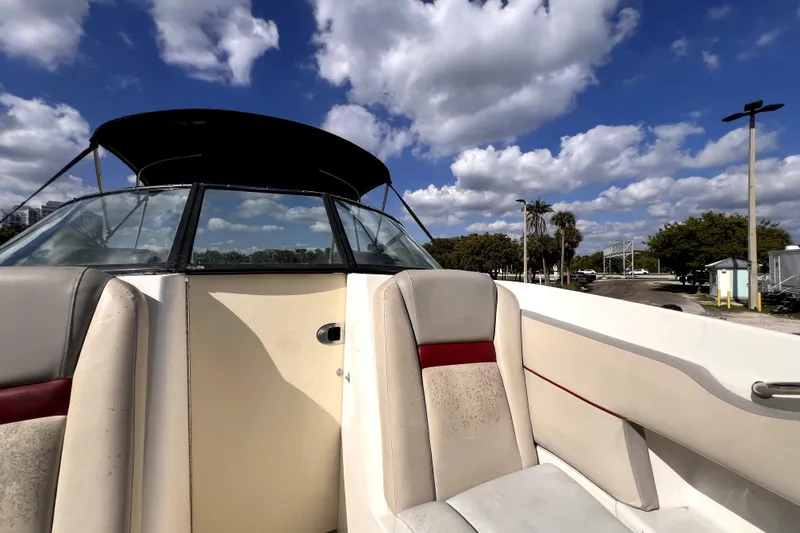 Slide: The Image of 2005 Sea Ray SLX 280 boat interior with white and red seating under a sunny sky. - 22