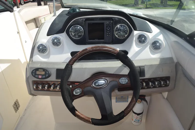 Slide: The Image of 2005 Sea Ray SLX 280 dashboard with Garmin navigation and wood-trimmed steering wheel. - 32