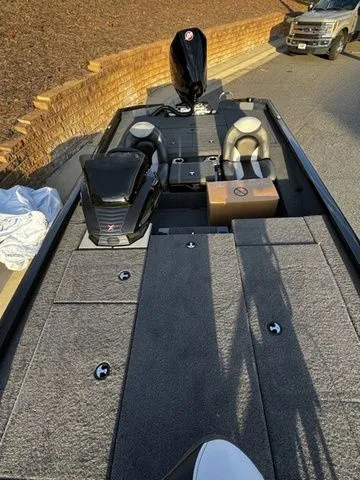 Slide: The Image of 2024 Vexus AVX2080 boat with spacious deck and seating, parked outdoors. - 12