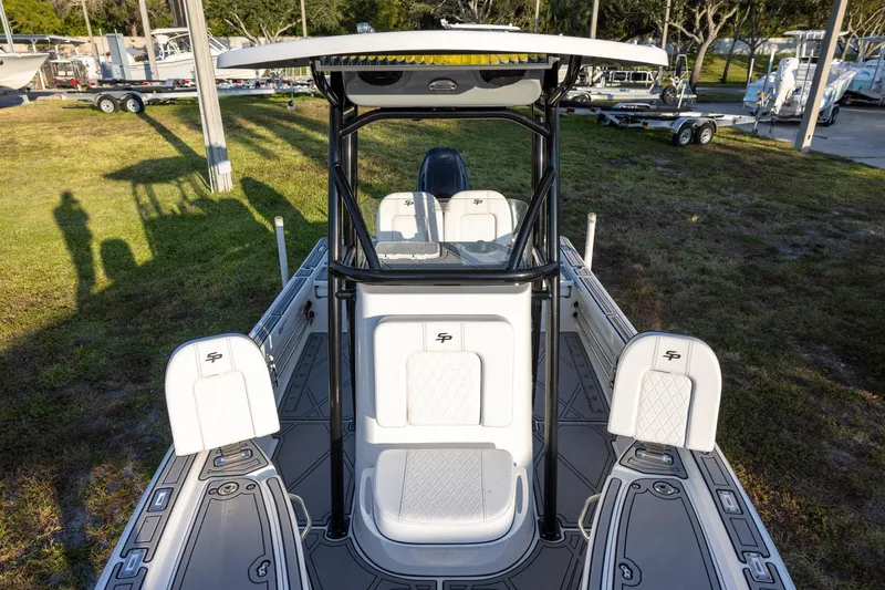 Slide: The Image of 2024 Sea Pro 210 Bay boat interior with seating and console, docked outdoors. - 14
