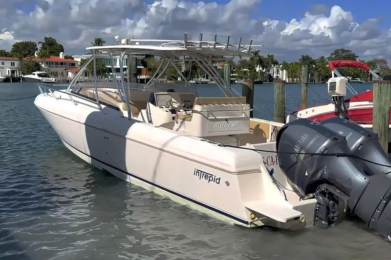 The Image of 2008 Intrepid 370 Cuddy boat docked in marina, featuring sleek design and spacious deck. - 0