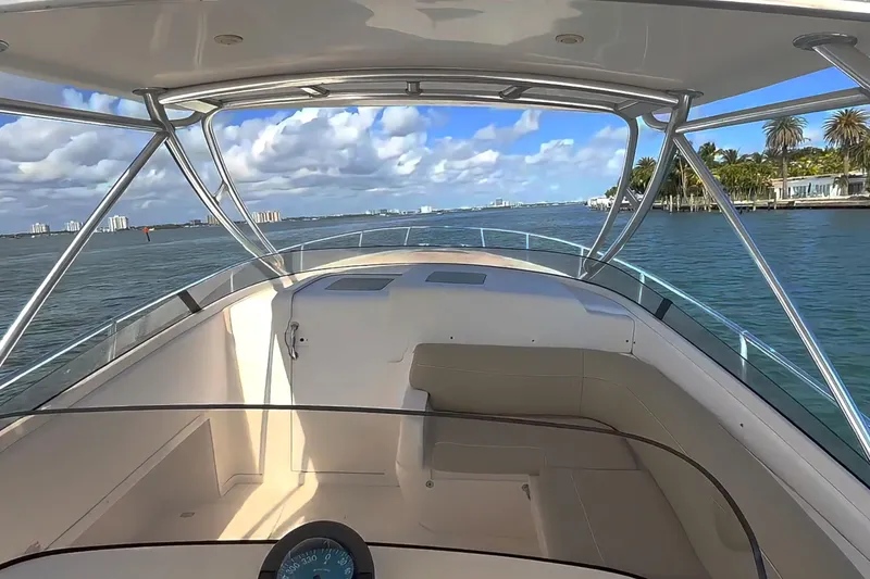 Slide: The Image of 2008 Intrepid 370 Cuddy boat docked in marina, surrounded by calm water and palm trees. - 1