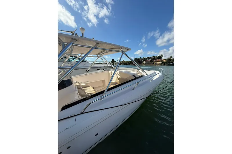 Slide: The Image of 2008 Intrepid 370 Cuddy boat docked with triple outboard engines under clear blue sky. - 14