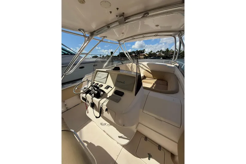 Slide: The Image of 2008 Intrepid 370 Cuddy boat docked, featuring spacious deck and seating under clear blue sky. - 22