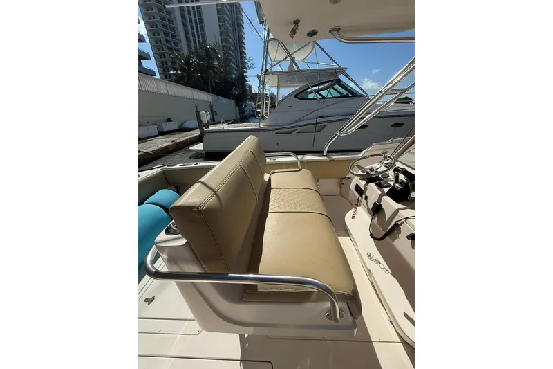 Slide: The Image of 2008 Intrepid 370 Cuddy boat docked, featuring spacious deck and fishing rod holders. - 23