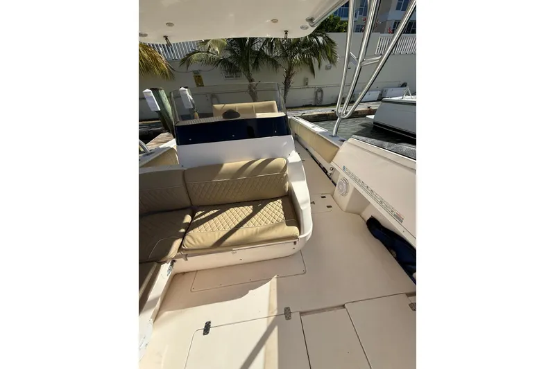 Slide: The Image of 2008 Intrepid 370 Cuddy boat interior with tan seating, docked by the water. - 42