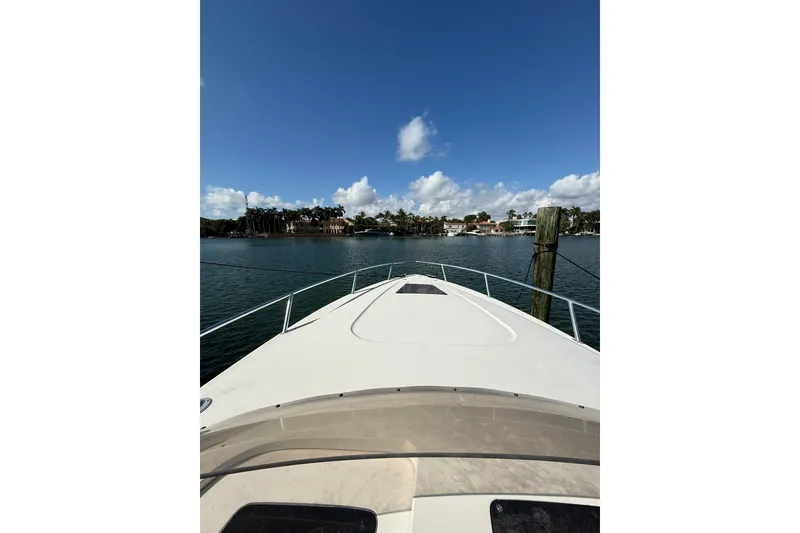 Slide: The Image of 2008 Intrepid 370 Cuddy boat interior with cushioned seating at a marina. - 45