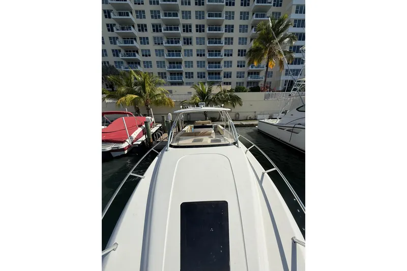 Slide: The Image of 2008 Intrepid 370 Cuddy boat interior with seating and helm, docked by the water. - 49