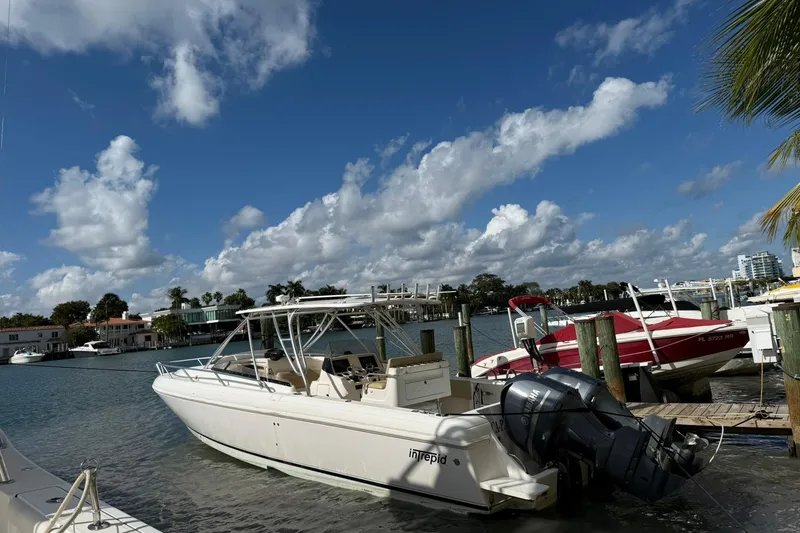 Slide: The Image of 2008 Intrepid 370 Cuddy boat docked in marina, surrounded by other vessels. - 5