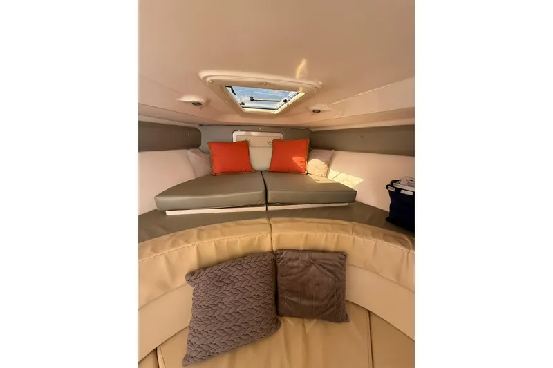 Slide: The Image of 2008 Intrepid 370 Cuddy boat interior with seating and storage, docked by waterfront homes. - 58
