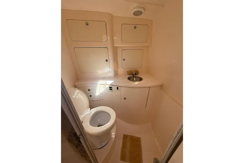 Slide: The Image of 2008 Intrepid 370 Cuddy boat bathroom with toilet, sink, and storage cabinets. - 71