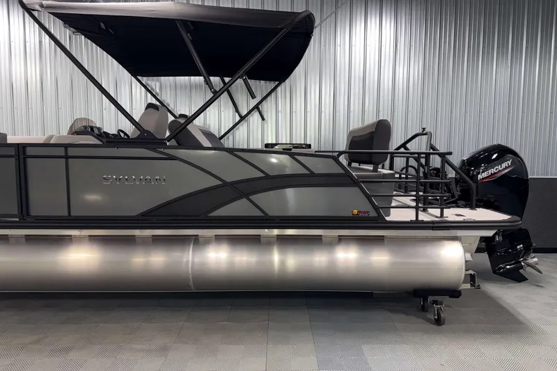 Slide: The Image of 2026 Sylvan L3 DLZ pontoon boat with Mercury outboard motor in showroom. - 25