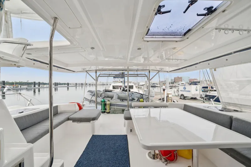 Slide: The Image of Spacious deck of 2016 Leopard 48 yacht with seating and table, docked at marina. - 105