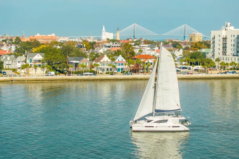 Slide: The Image of Sailboat Leopard 48 cruising near colorful waterfront homes and bridge, 2016 model. - 115