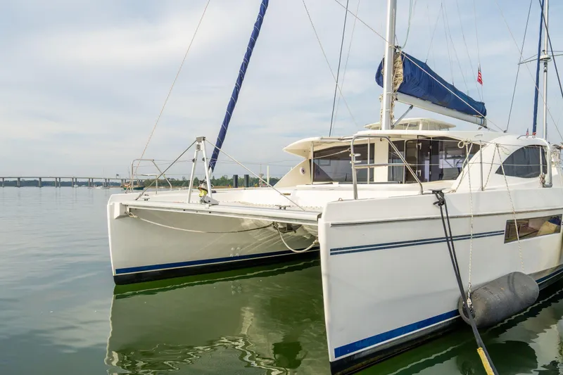 Slide: The Image of 2016 Leopard 48 catamaran docked on calm water, featuring sleek design and spacious deck. - 27