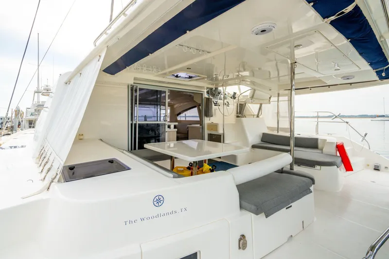 Slide: The Image of Luxurious 2016 Leopard 48 yacht with spacious outdoor seating and dining area, docked at marina. - 30