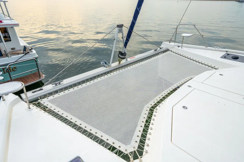 Slide: The Image of 2016 Leopard 48 catamaran with netted deck, docked beside another boat. - 55