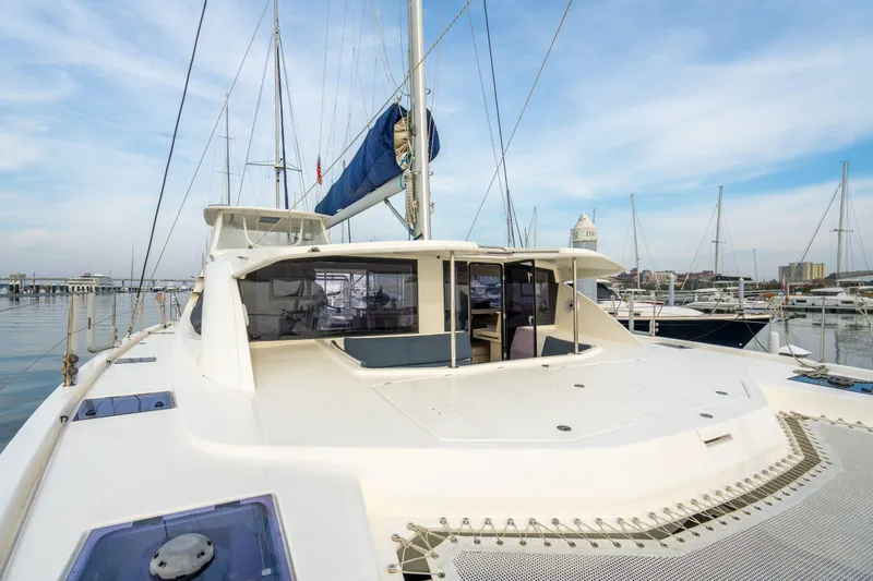 Slide: The Image of 2016 Leopard 48 catamaran docked at marina, showcasing spacious deck and modern design. - 58