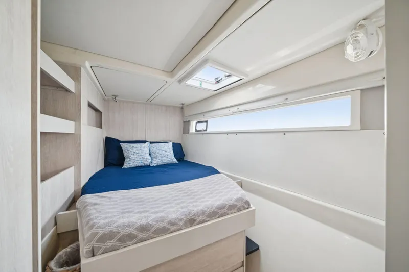 Slide: The Image of Cozy bedroom interior on 2016 Leopard 48 yacht with blue bedding and natural light. - 80