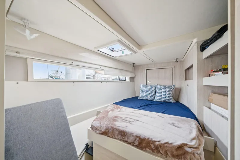 Slide: The Image of Cozy cabin interior of 2016 Leopard 48 yacht with bed, windows, and storage shelves. - 88