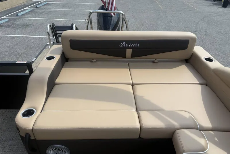 Slide: The Image of 2025 Barletta Cabrio 24U boat interior with beige seating and cup holders. - 20