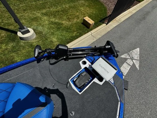 Slide: The Image of 2024 Vexus VXS20 boat with Garmin equipment and blue seating, parked on pavement. - 11