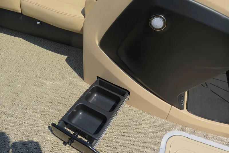 Slide: The Image of 2026 Barletta Cabrio 24UC boat interior with pull-out storage drawer and beige seating. - 12