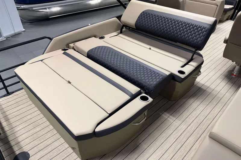Slide: The Image of 2026 Sylvan L3 DLZ boat interior with beige and black seating, cup holders, and textured upholstery. - 19