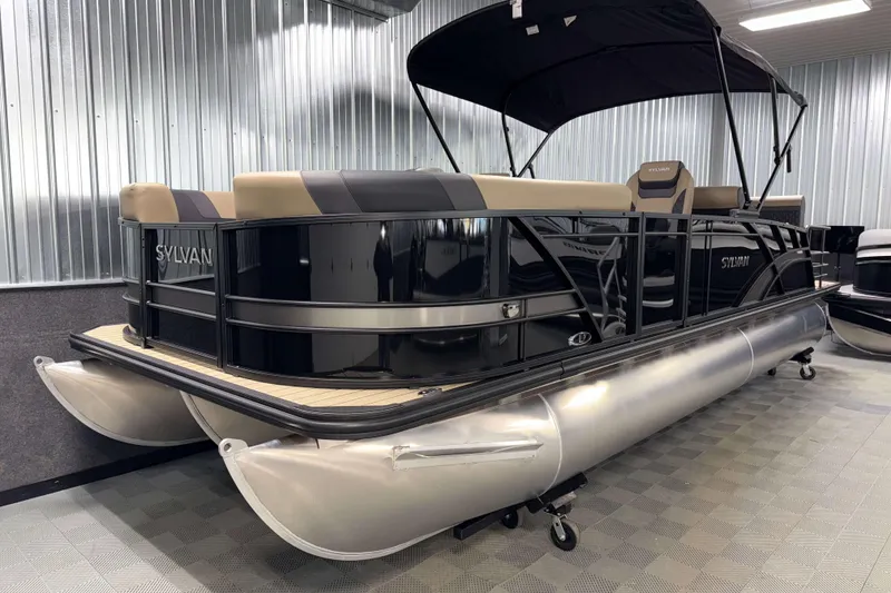 Slide: The Image of 2026 Sylvan L3 DLZ pontoon boat with sleek black and beige design in showroom. - 22