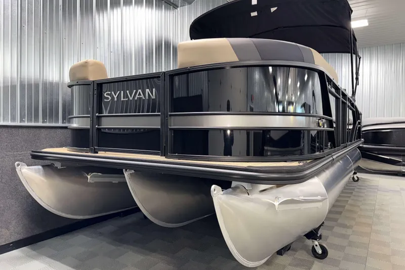 Slide: The Image of 2026 Sylvan L3 DLZ pontoon boat in showroom, featuring sleek black and silver design. - 24