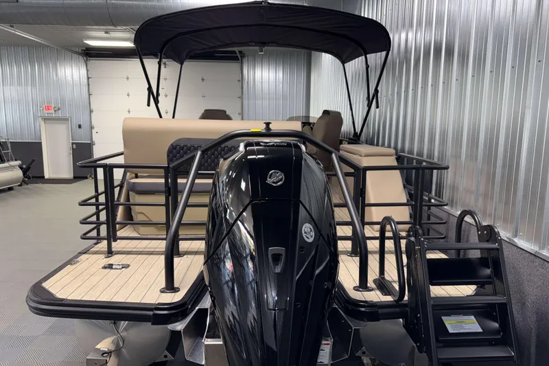 Slide: The Image of 2026 Sylvan L3 DLZ pontoon boat with black motor in a showroom. - 30