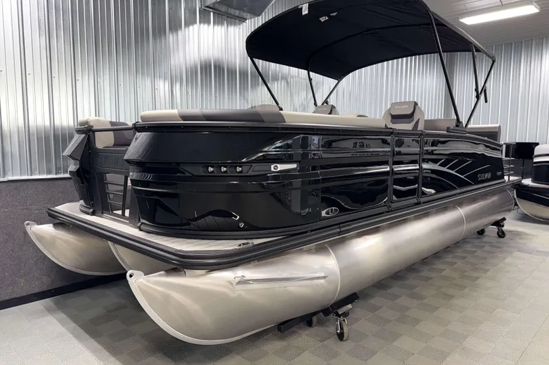 Slide: The Image of 2026 Sylvan L3 DLZ Platinum pontoon boat in showroom, sleek black design. - 21