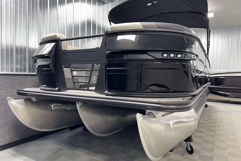 Slide: The Image of 2026 Sylvan L3 DLZ Platinum pontoon boat in a showroom setting. - 23