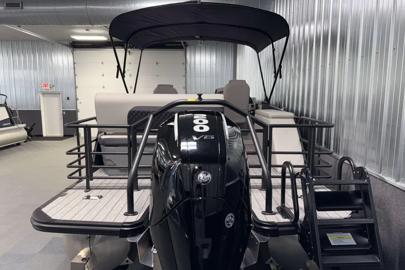 Slide: The Image of 2026 Sylvan L3 DLZ Platinum pontoon boat with powerful outboard motor in showroom. - 29