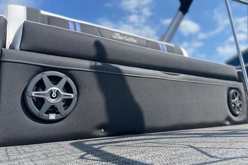 Slide: The Image of 2025 Barletta Corsa 23U boat interior with speakers, under a clear blue sky. - 5